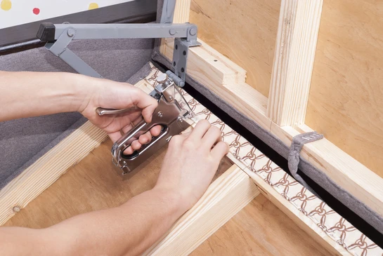 Atelier d'ébénisterie avec artisan assemblant un meuble en bois massif